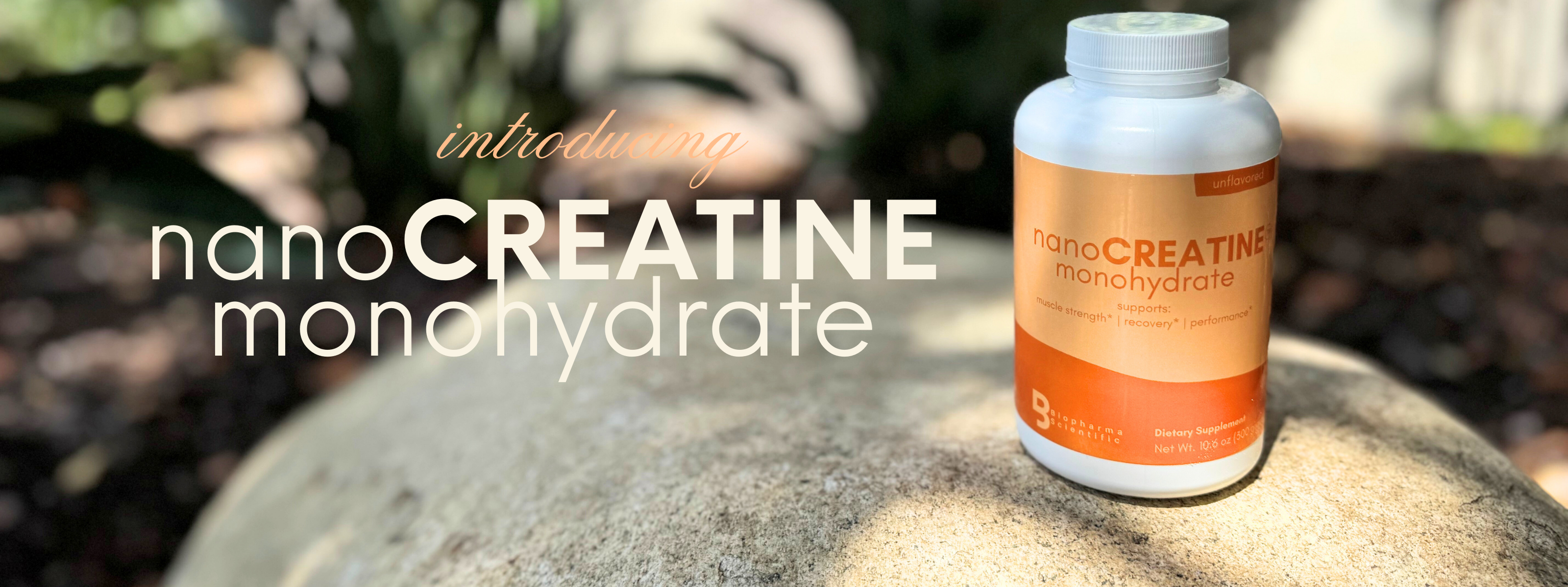 Bottle of nanoCREATINE monohydrate on a rock with blurred natural background